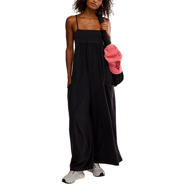 Woman in a black maxi dress holding a pink bag.