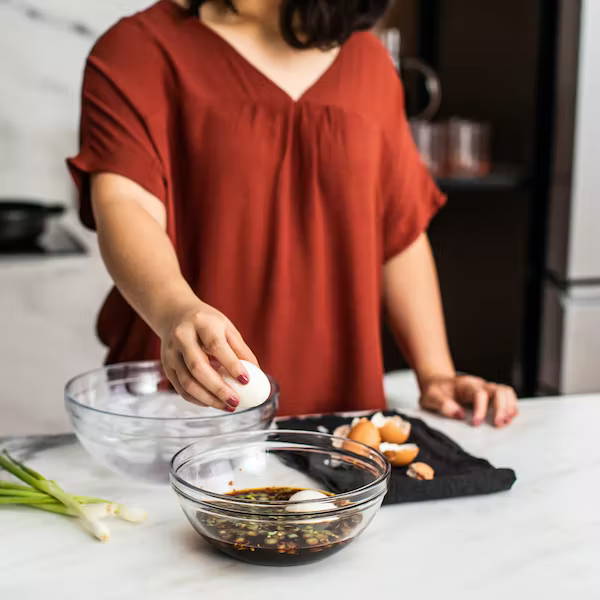 Woman making soy sauce eggs