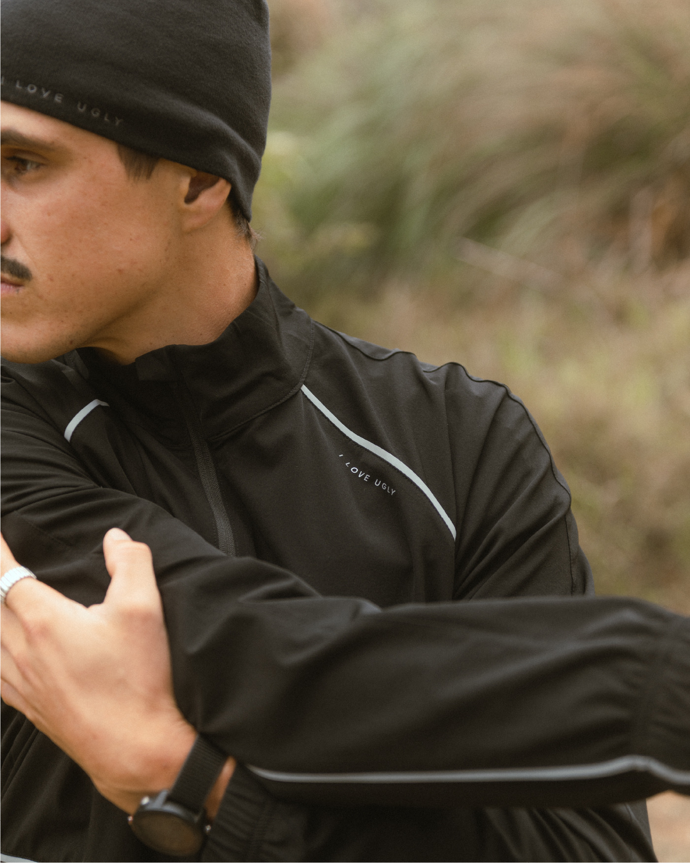 A man stretching in athletic wear outdoors.