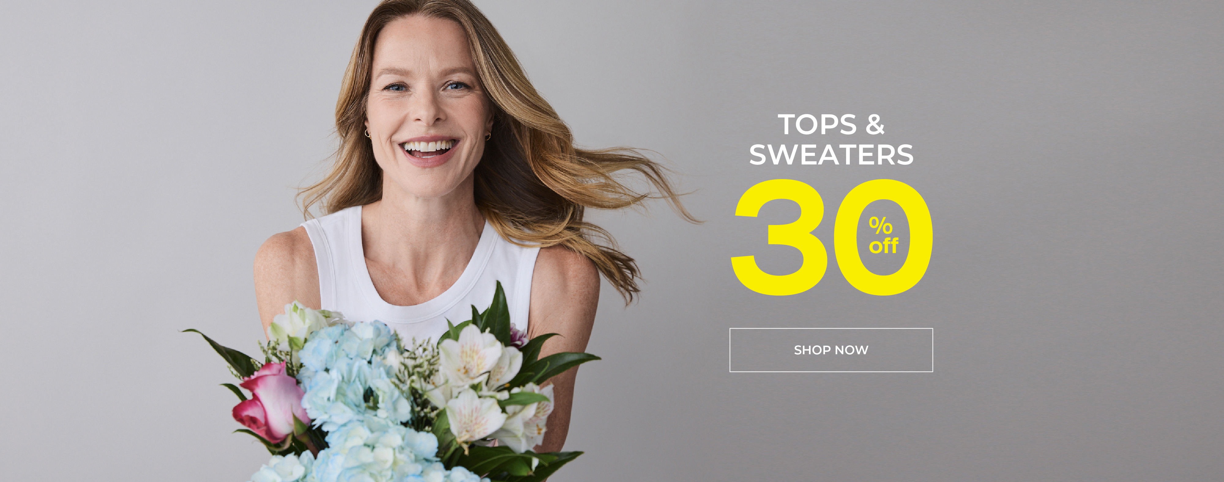 Smiling woman holding flowers with promotional text for a 30% off tops and sweaters.