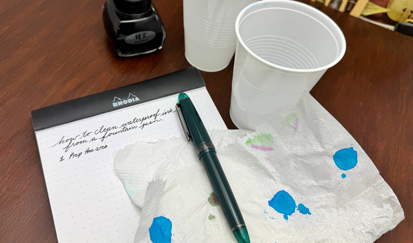 Sailor 1911 Fountain Pen in Call of Cthulhu resting on a notebook with a piece of paper towel and two cups