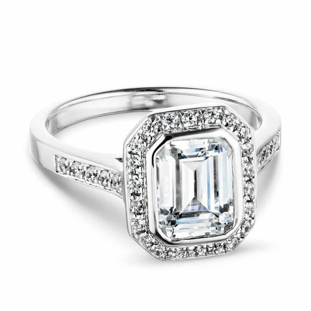 antique style halo engagement ring Shown with a 1.0ct Emerald cut Lab-Grown Diamond with a diamond accented halo and diamond accented band in recycled 14K white gold