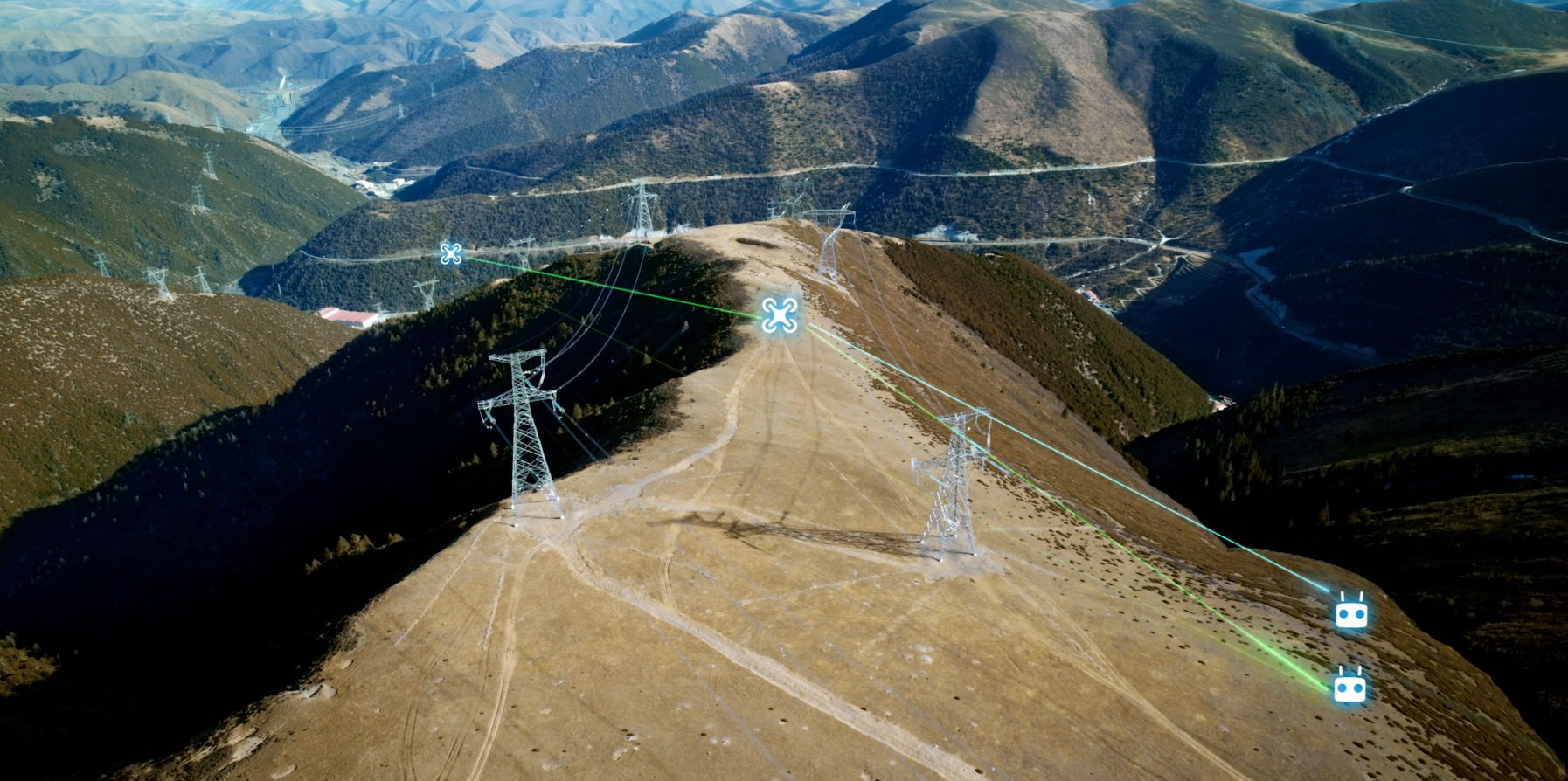 Aerial view of mountainous terrain with power lines and pylons.