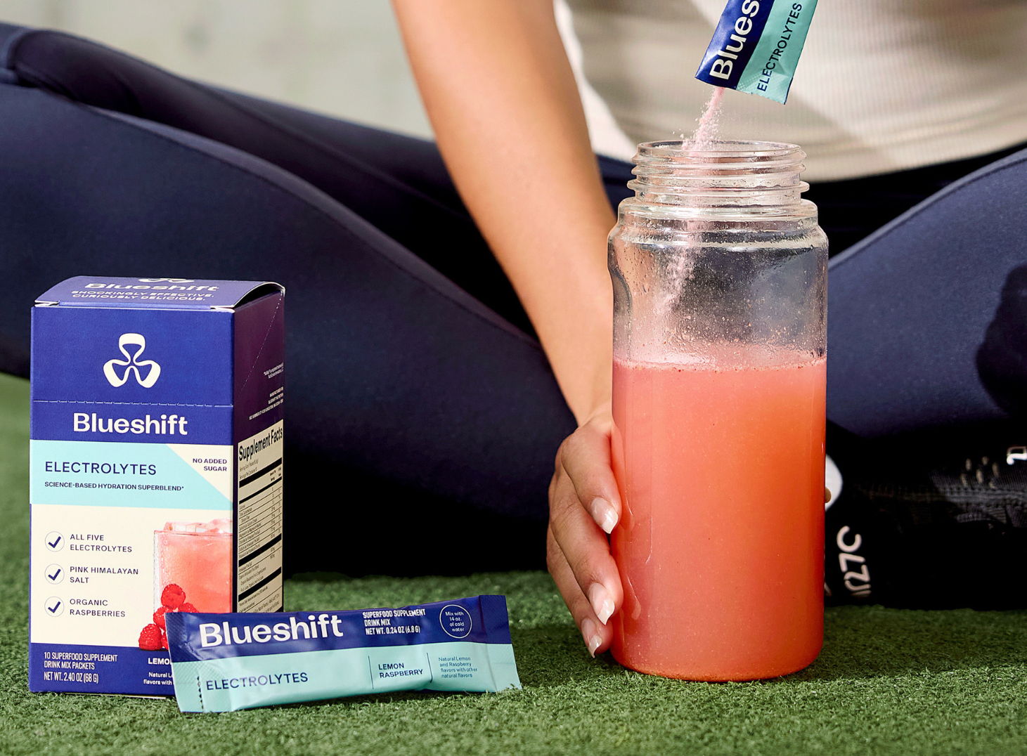 Woman in activewear pouring Electrolytes into a clear bottle
