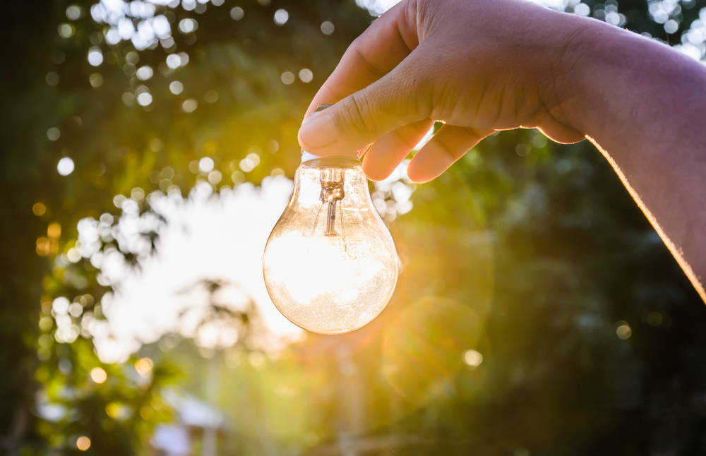 person holding light bulb with sunlight shining through|How I overcame my empath tendencies  of picking up other people' s energy