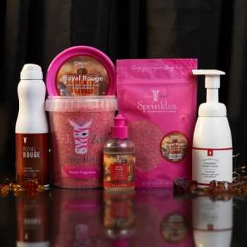 Bottles and containers of beauty products on a reflective surface.