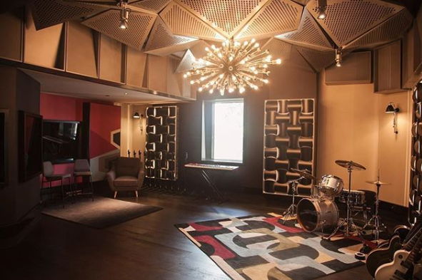Modern music studio with a drum set and stylish lighting.