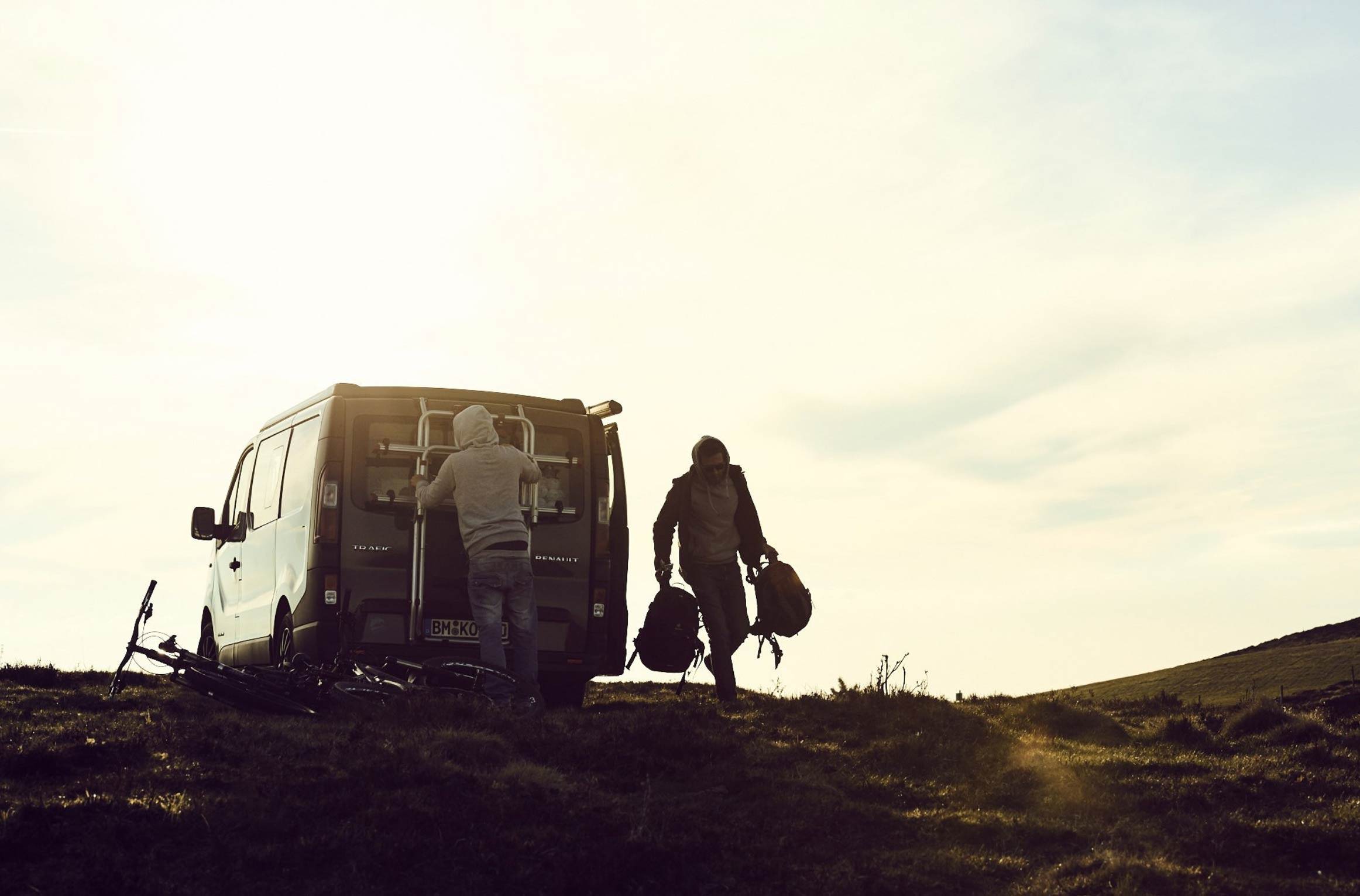 Landschaft und Van mit 2 Sportlern