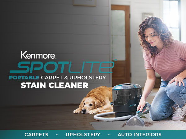 Woman using Kenmore SpotLite stain cleaner on carpet near a dog.