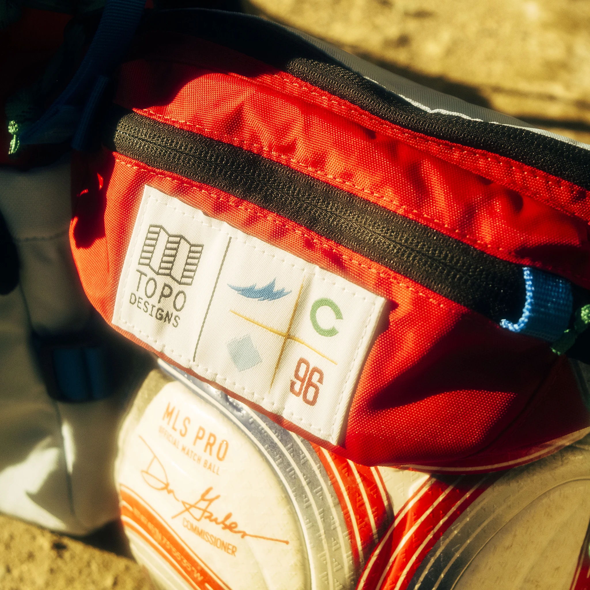 Red pouch with patches on top and circular items below it.