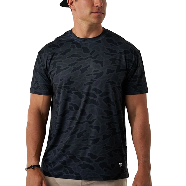 Man wearing a dark camo-patterned t-shirt and casual shorts.