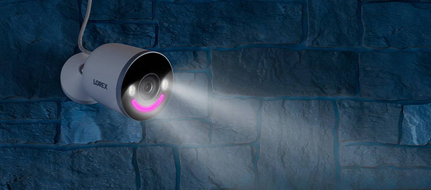 Lorex Smart Security Lighting Wi-Fi Camera on brick wall at night