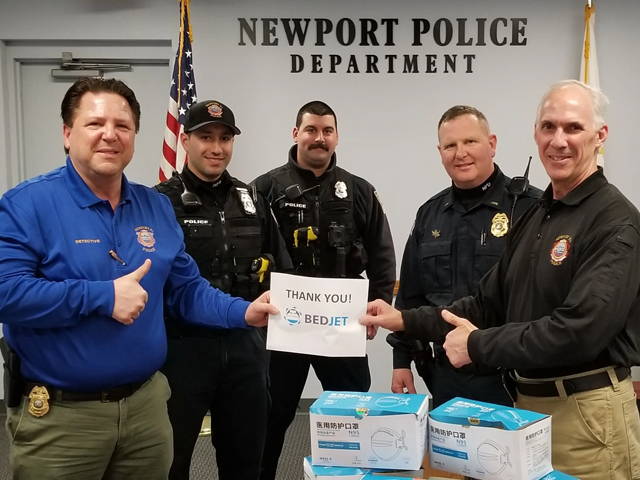 Members of the Newport Police Department pose with a sign that says 
