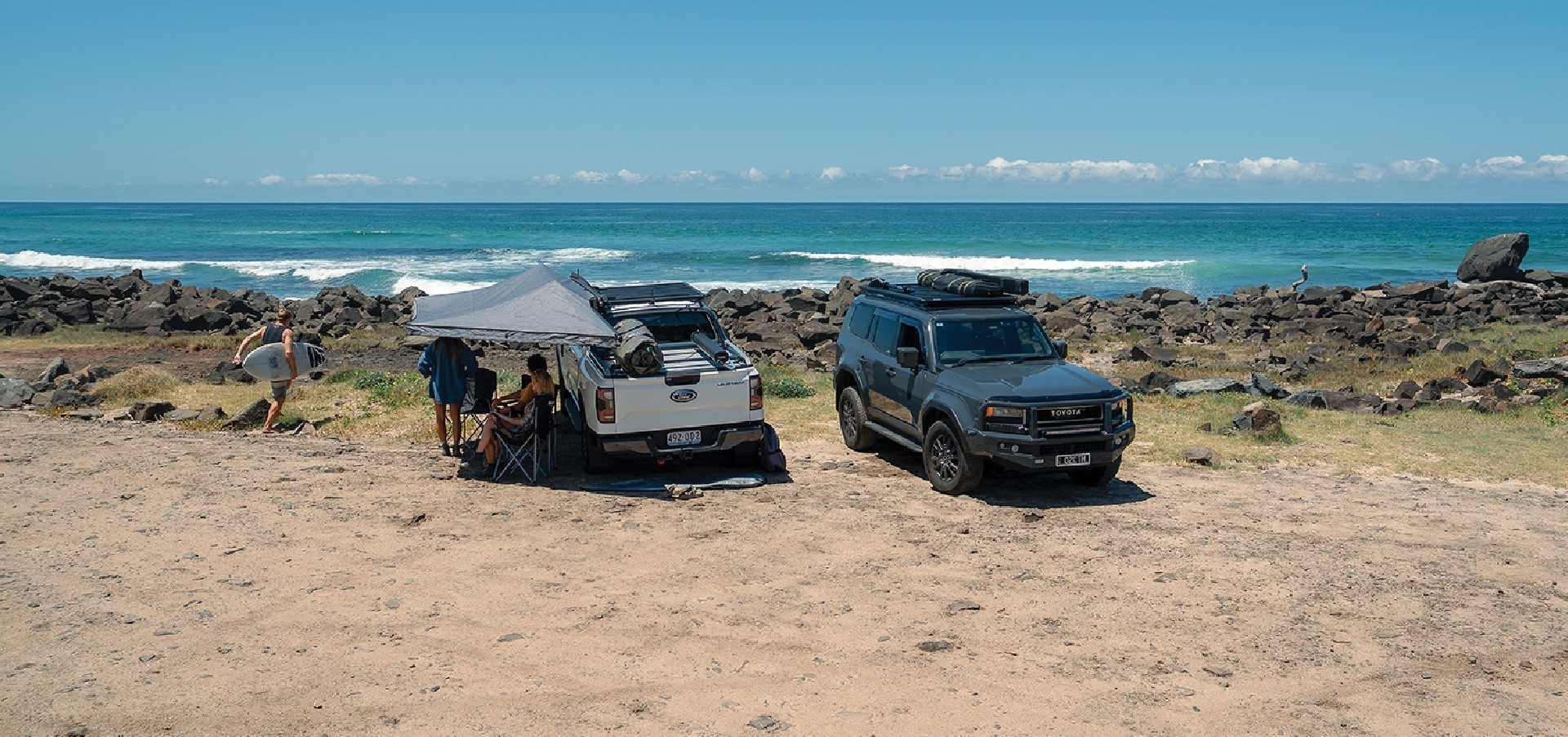 Two vehicles setup for camping in front of the beach. Both with Ykaima LockNLoad Platform and Ruggedline setups
