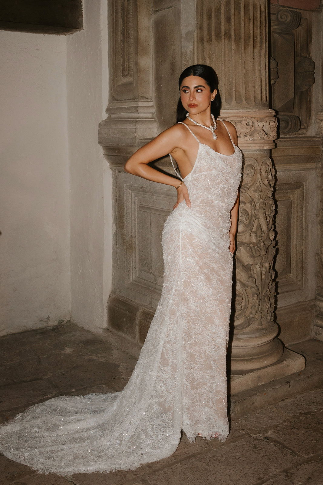 Bride in her second look next to concrete building