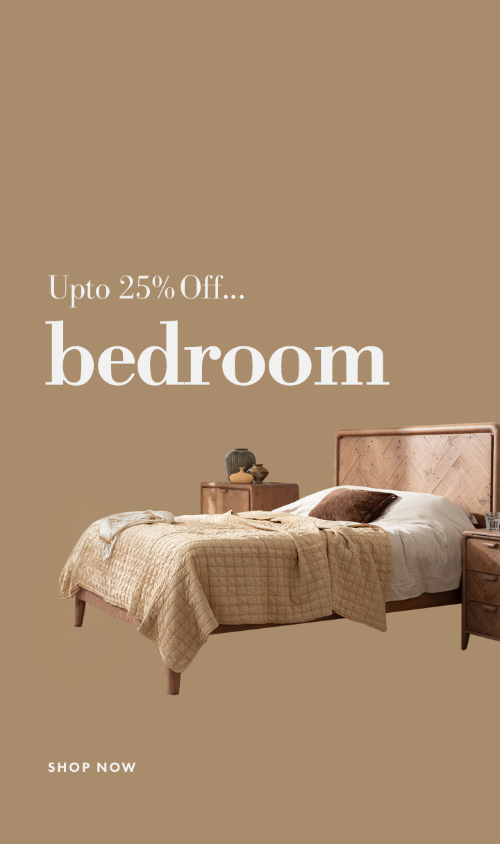 A cozy bedroom corner with a nightstand, lamp, and decorative items.