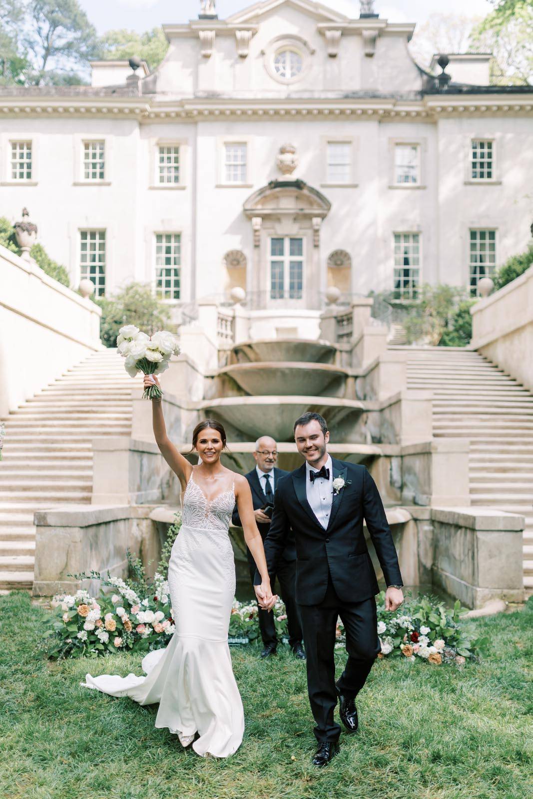 Bride and Groom with the bride holding her bouquet in the air, creating a celebrating and joyful atmosphere.