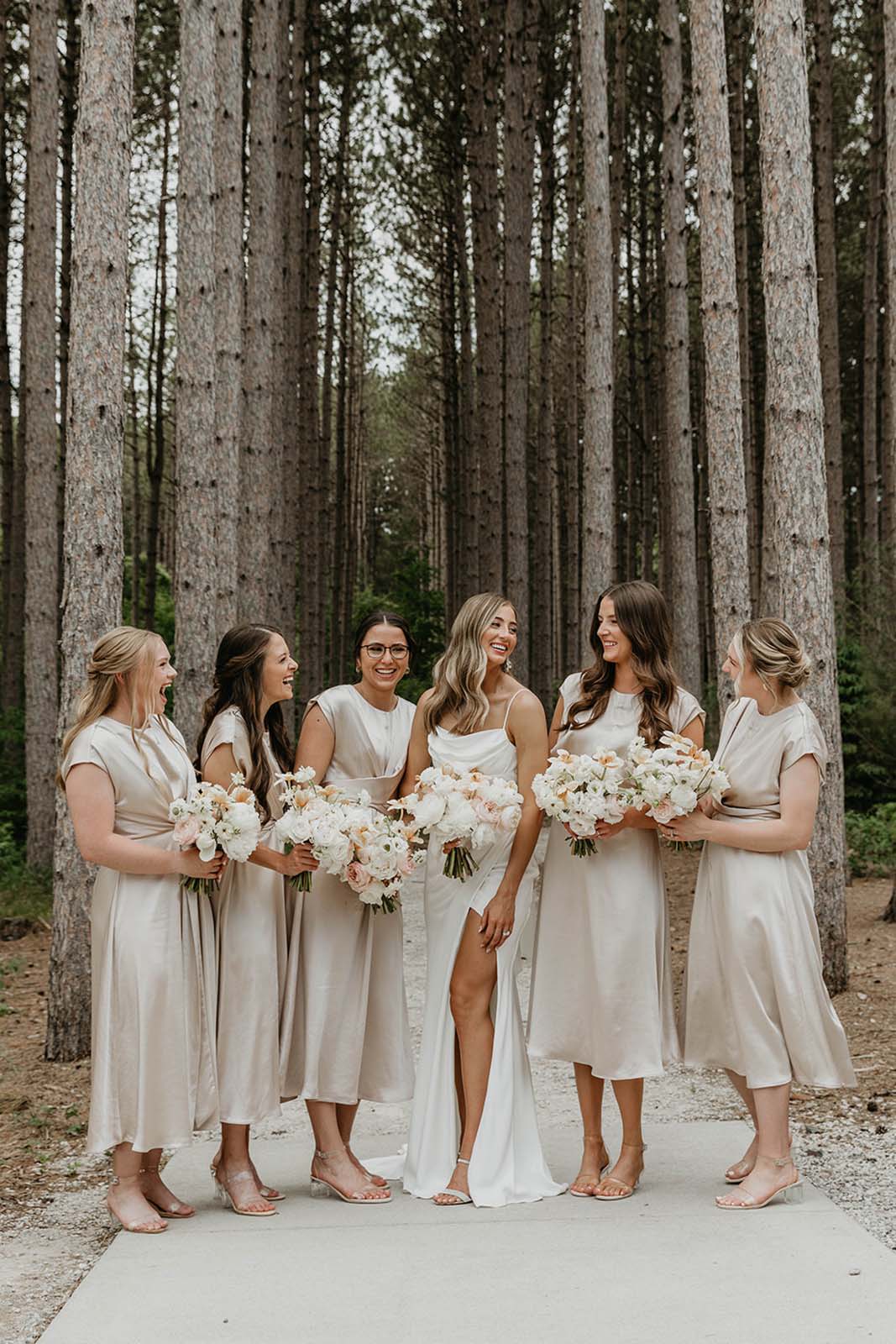 Bride, standing alongside with her bridesmaid in the pinewood forest