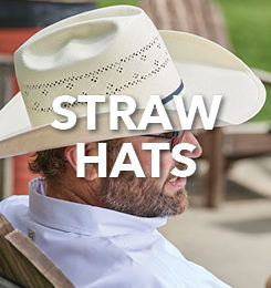 A person wearing a straw hat sitting outdoors.