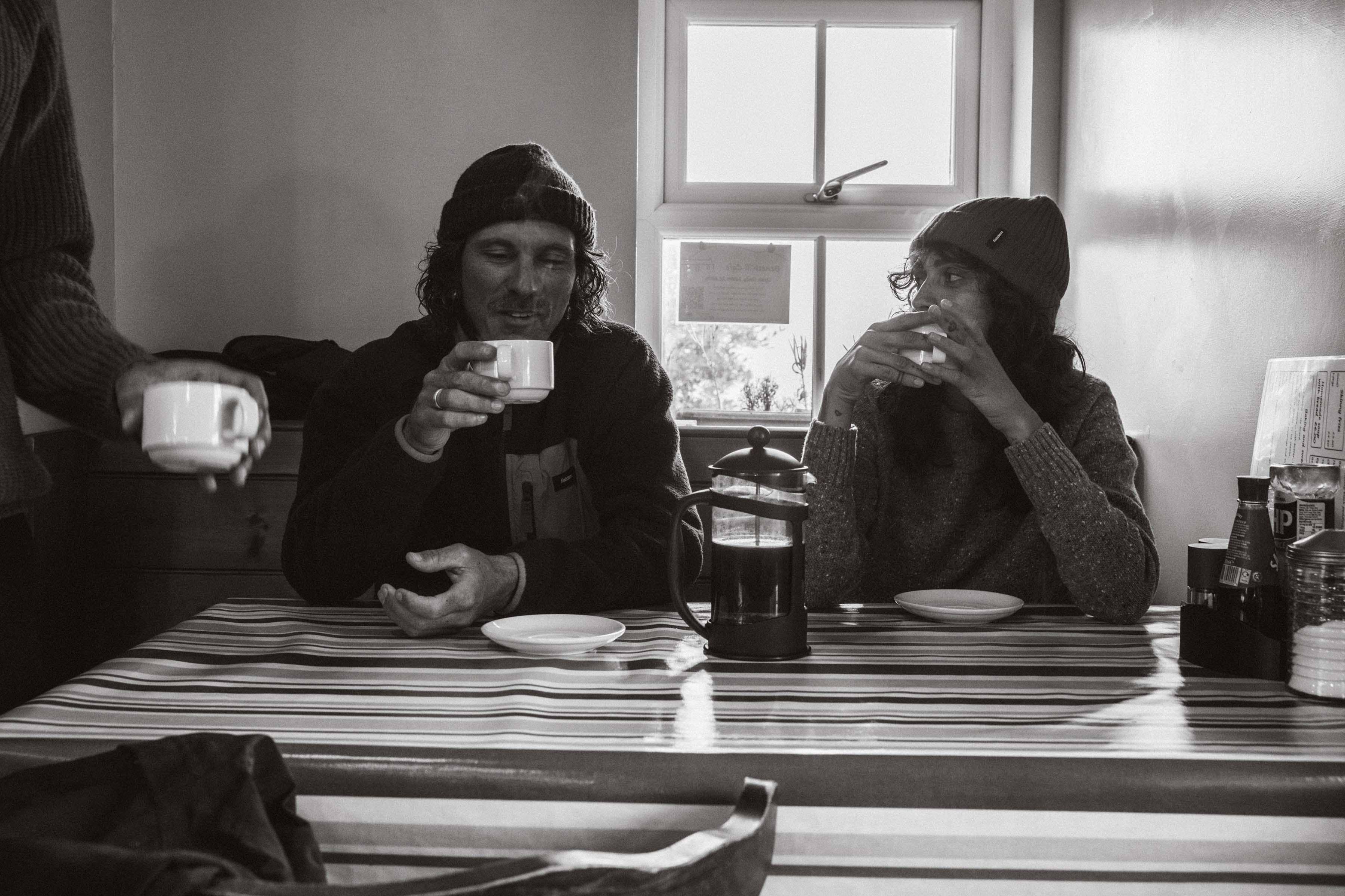 Two people enjoying coffee at a table in a cosy setting.