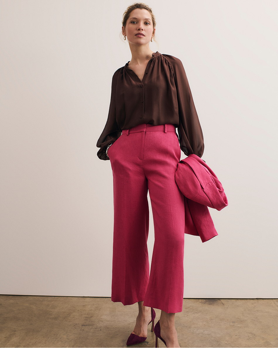 Model wearing fuchsia pink Assisi trousers and chocolate Riola blouse