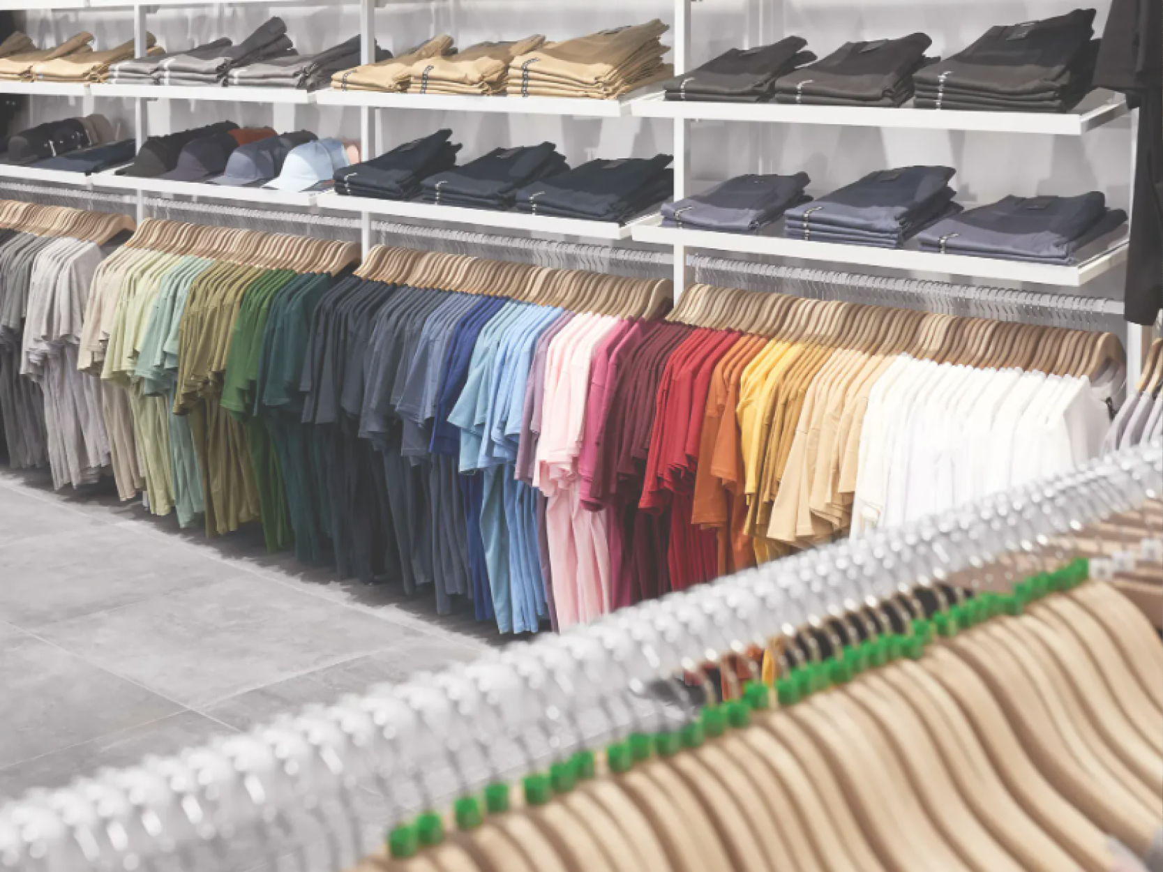 Clothes displayed on shelves and hangers in a retail store.