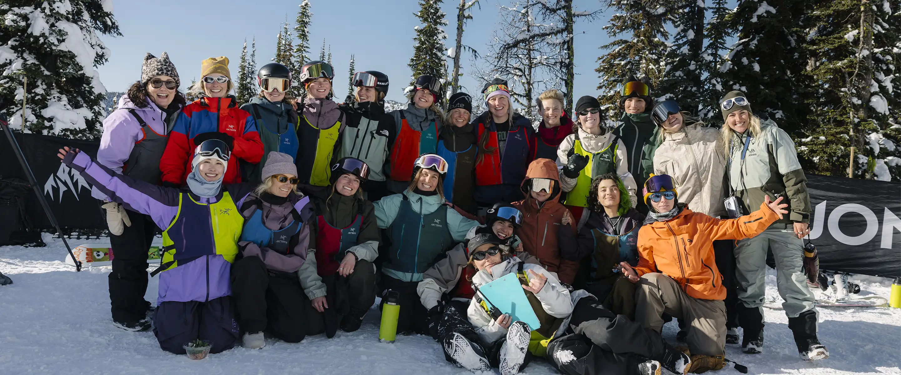 Group of people in winter attire posing on snow-covered mountain.