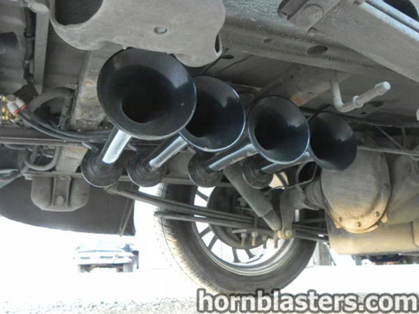 Underbody close-up of four black train horn bells mounted near the rear axle on Thomas's Silverado, install photo 5