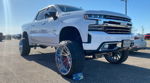 Front three-quarter Cristian's lifted white Chevrolet Silverado with chrome wheels and red accents photo 1
