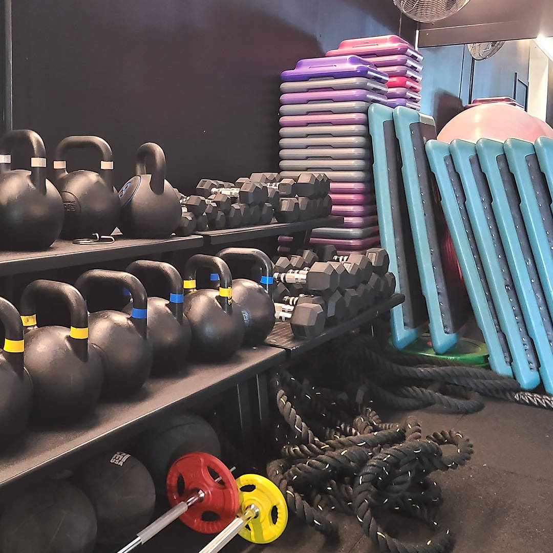 Commercial gym fit-out featuring a robust selection of Force USA kettlebells and slam balls for dynamic strength training.