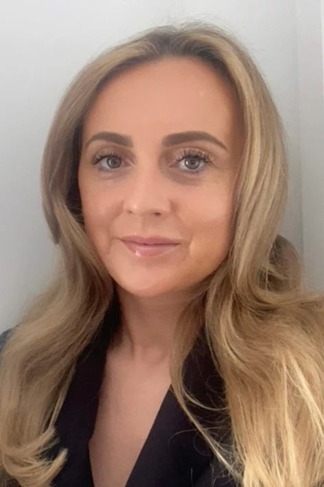 Portrait of a woman with long, blonde hair and a black blouse.