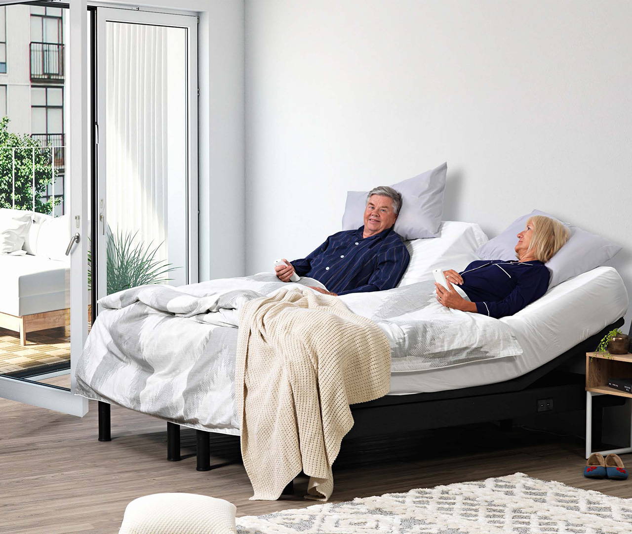 Man and woman lying on adjustable bed bases