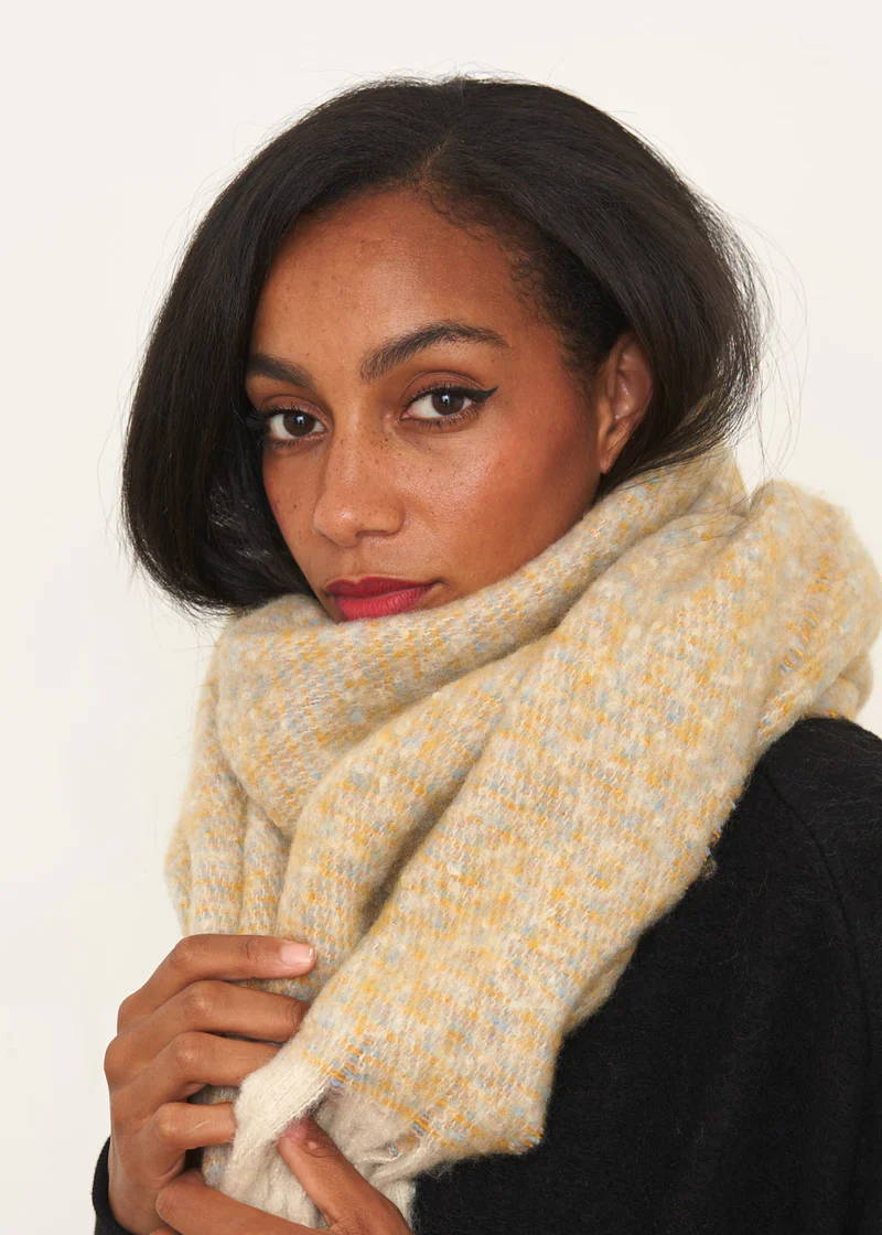 A model wearing a mustard marled wool blend scarf