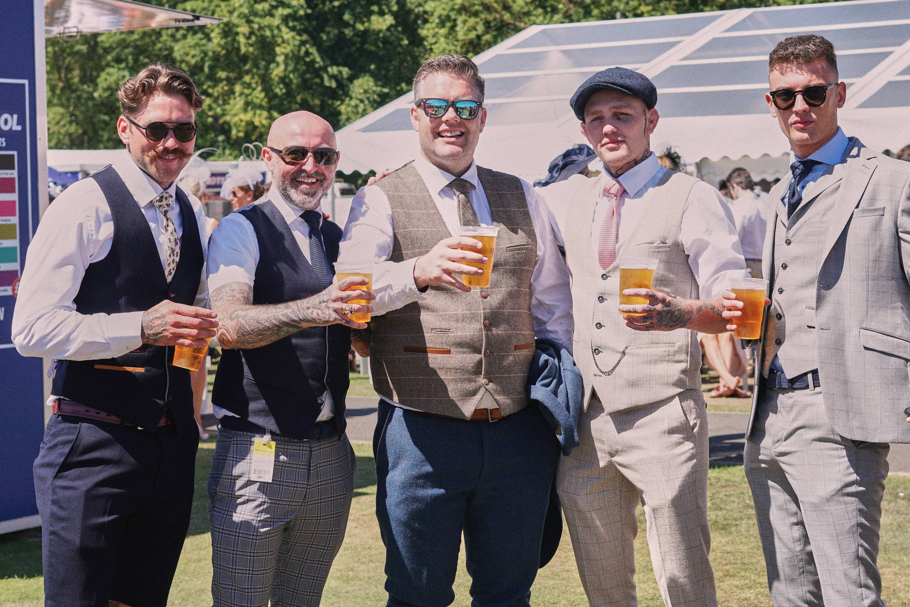 men wearing waistcoats and suits at the horse races