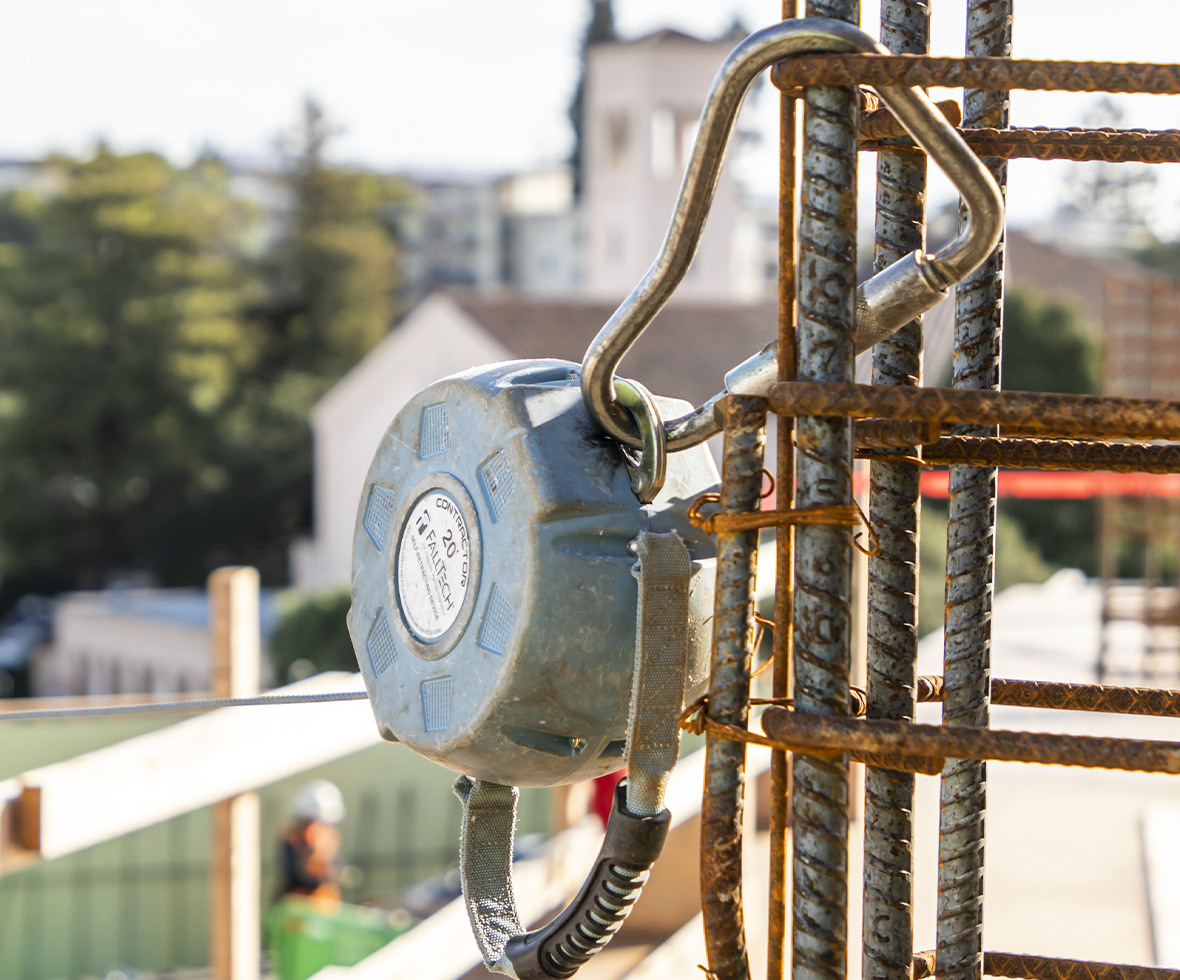 Contractor self-retracting lifeline block anchored with a carabiner to rebar