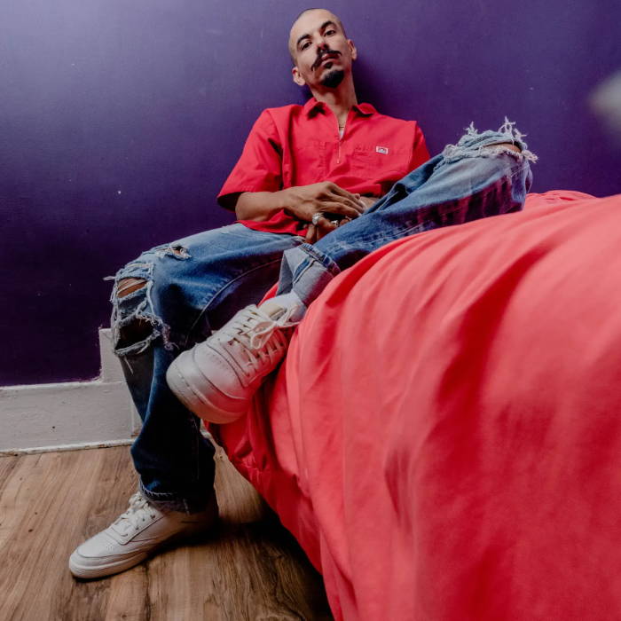 man sitting on bed wearing white reebok shoes