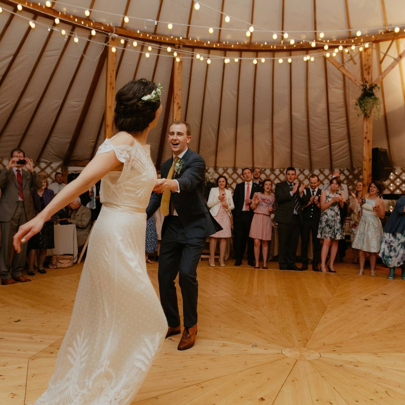 Bride and groom dancing at a wedding surrounded by friends. 