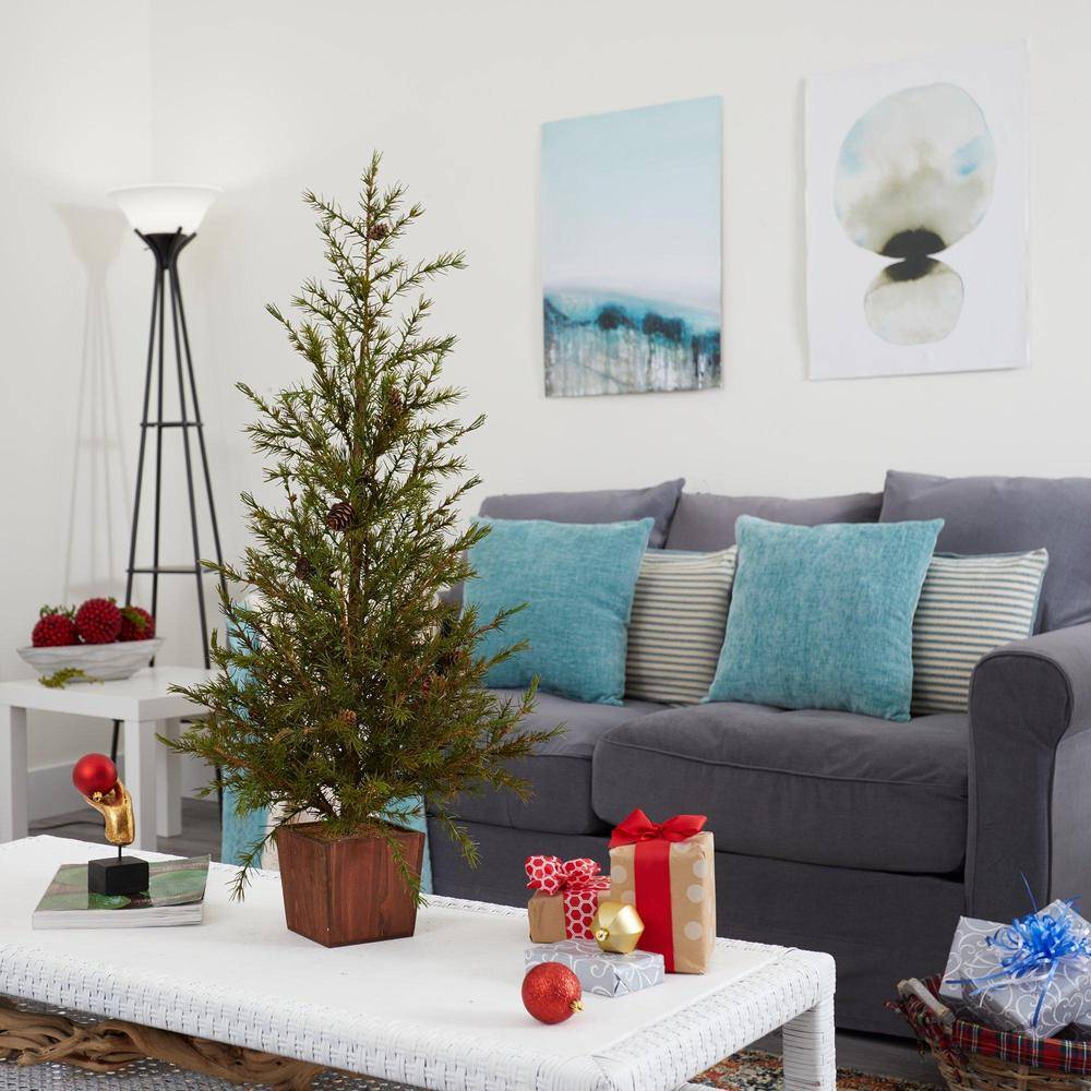 Artificial Christmas tree from Nearly Natural situated in a small apartment living room with Christmas presents on the table and a grey sofa