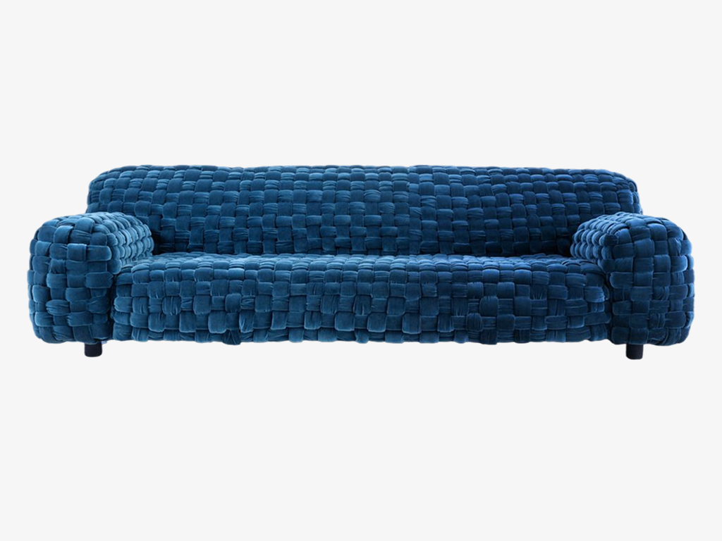 A modern blue tufted sofa with rounded arms and short legs.