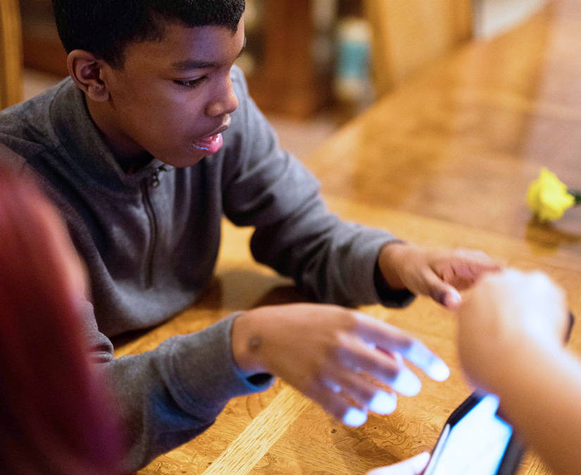 Young teen using Tobii Dynavox Snap Scene at dinner table