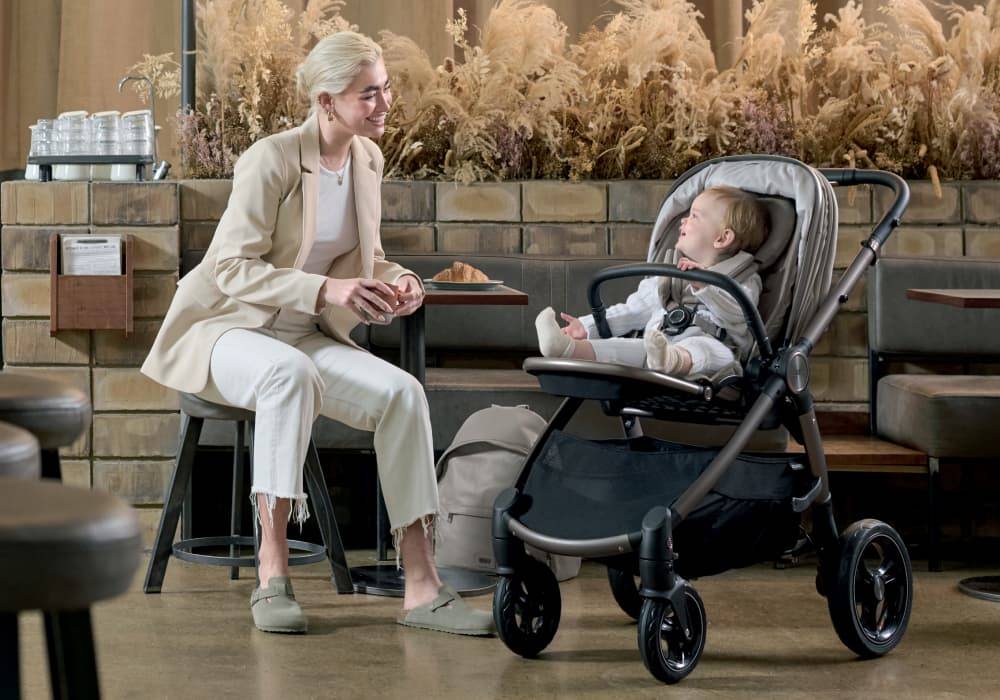 Women smiling at baby sat in an Ocarro pushchair