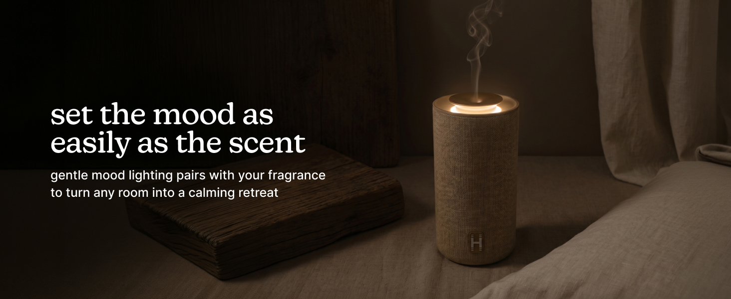 A lit candle on a table with soft lighting and fabric backdrop.