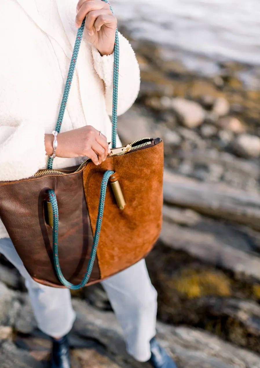 woman unzipping leather bag