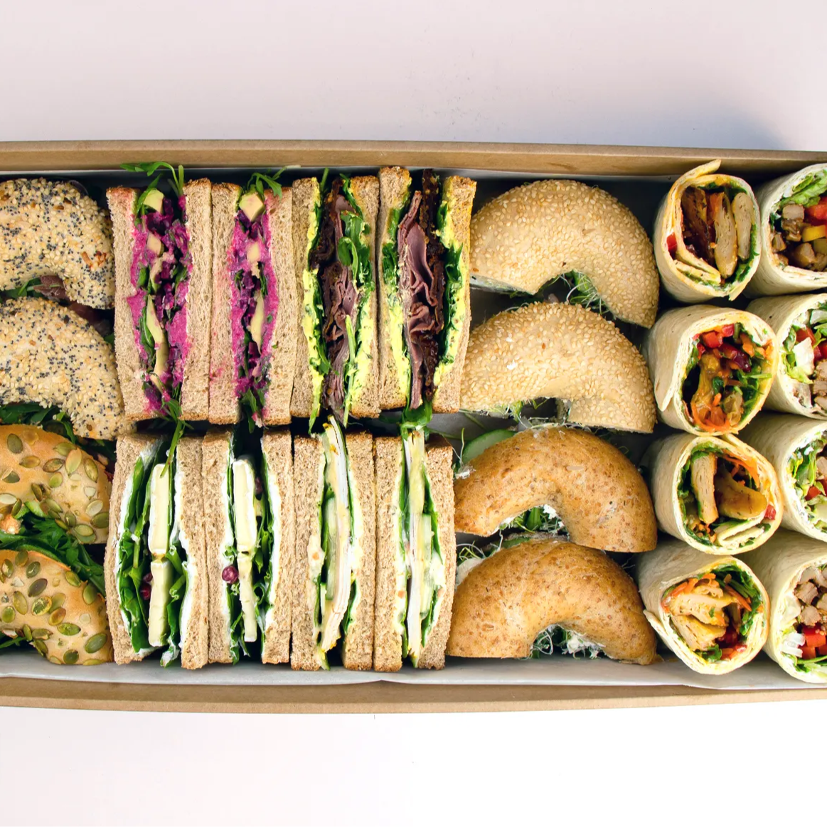 Ausschnitt einer Box mit Sandwiches, Bagels und Wraps