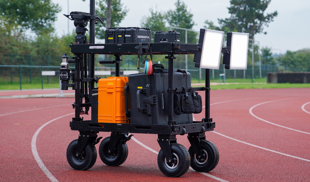 A mobile robotic cart with equipment on a track field.