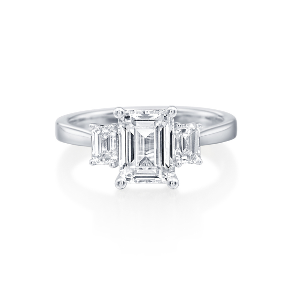 Elegant three-stone diamond ring with emerald-cut center and side stones.