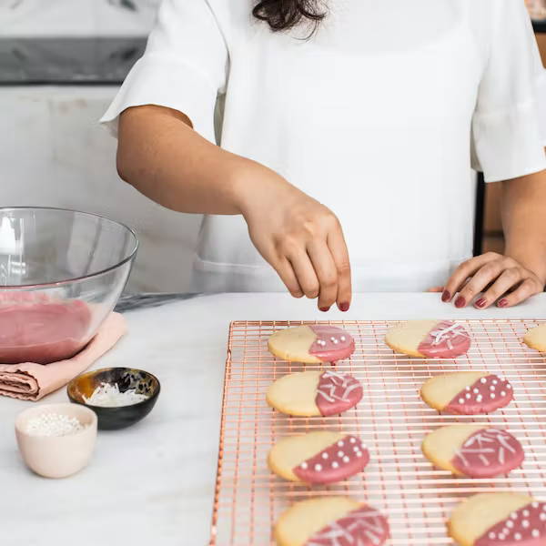 woman decorating chocolate dipped cookies