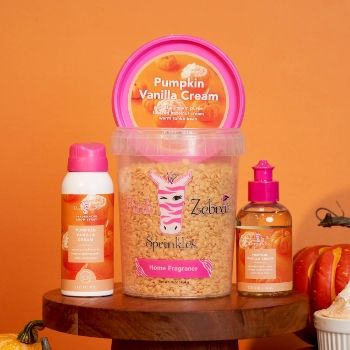 Pumpkin vanilla cream and body care products on a wooden surface against an orange background.