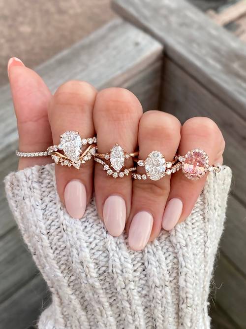 multiple styles of engagement rings on hand
