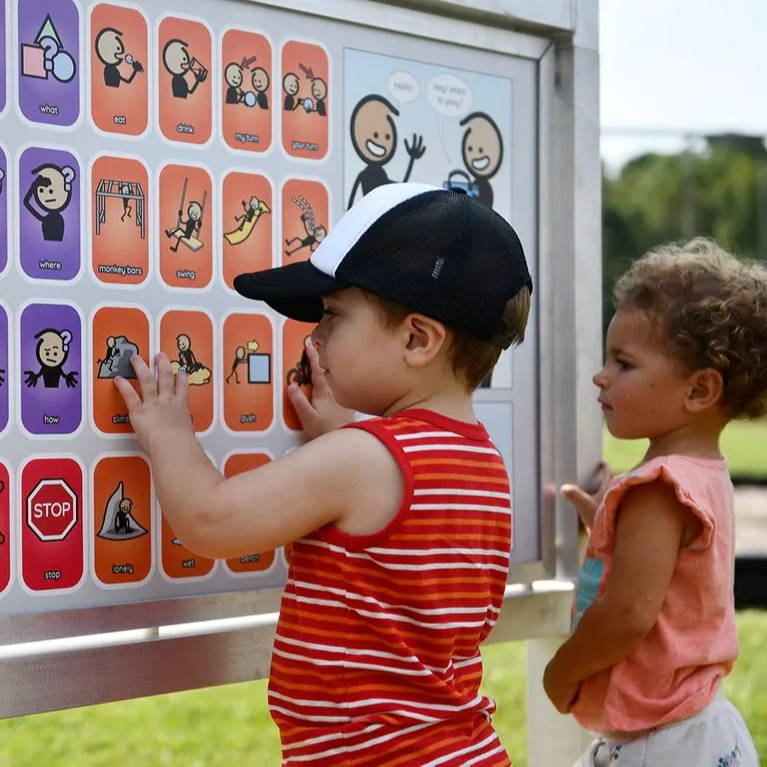 Children engaging with playground post mount communication board